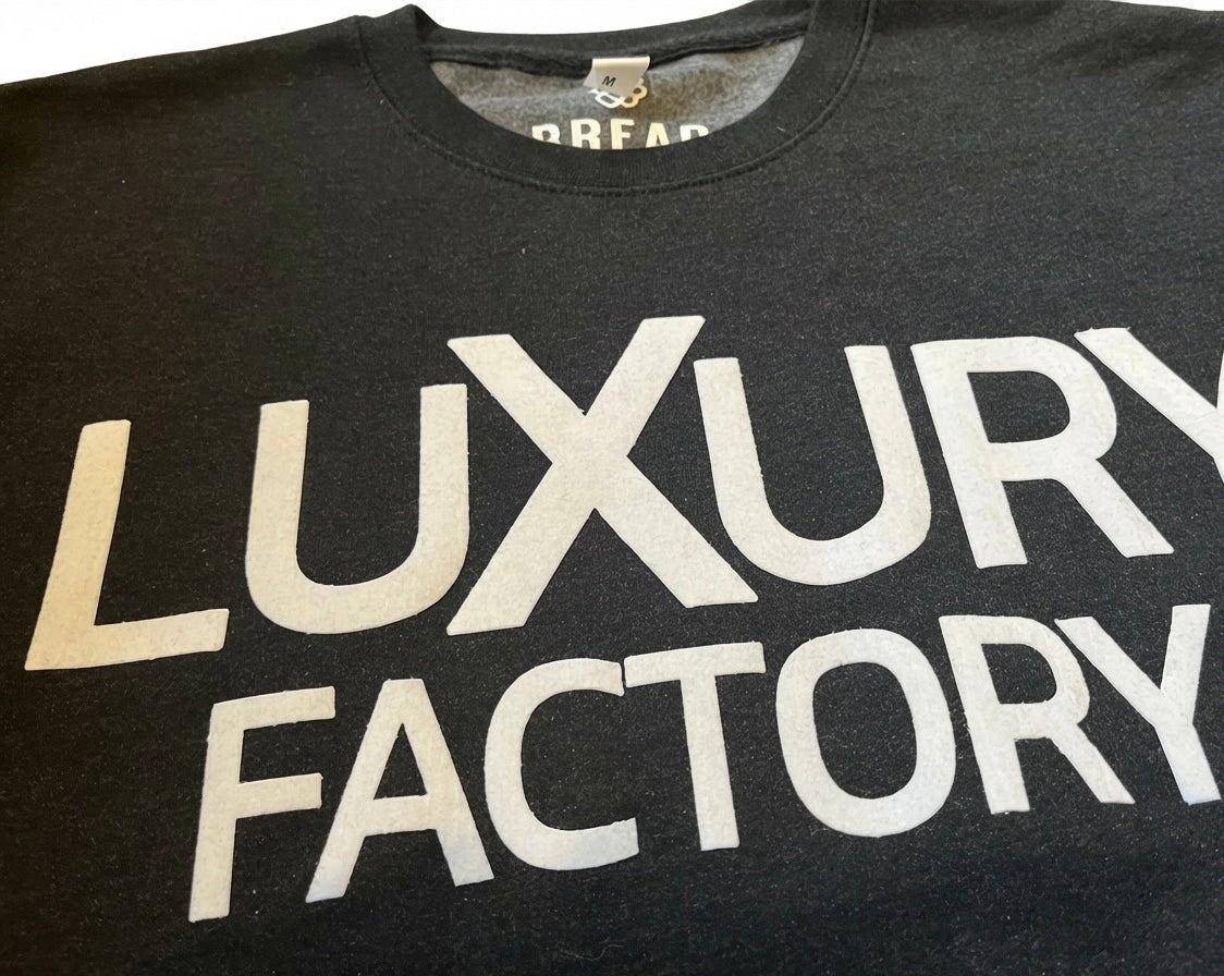 Black tank top with 'Luxury Factory' text in white on a white background